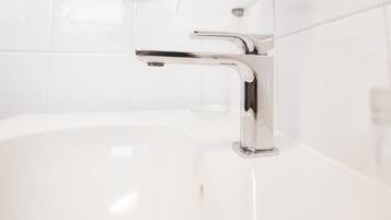 A modern bathroom with a chrome faucet and a white sink.