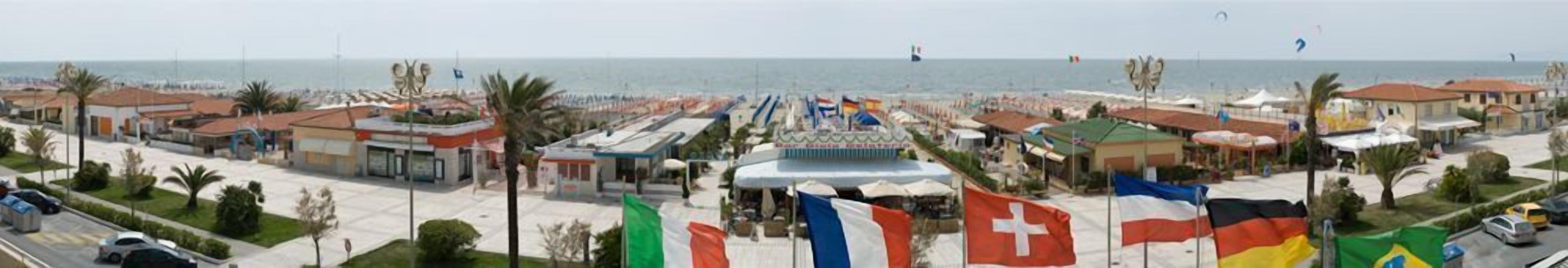 A coastal town with a beach, flags, and buildings.