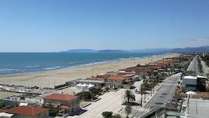 A coastal town with a beach, buildings with red roofs, and a clear blue sky. - Hotel Residence Villa Jolanda (Camaiore)