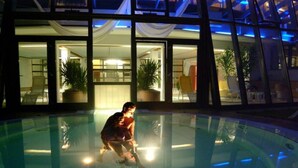 Un hombre en una piscina con un edificio al fondo.
