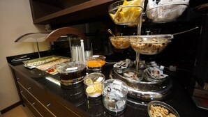 A buffet setup with various food items and beverages.