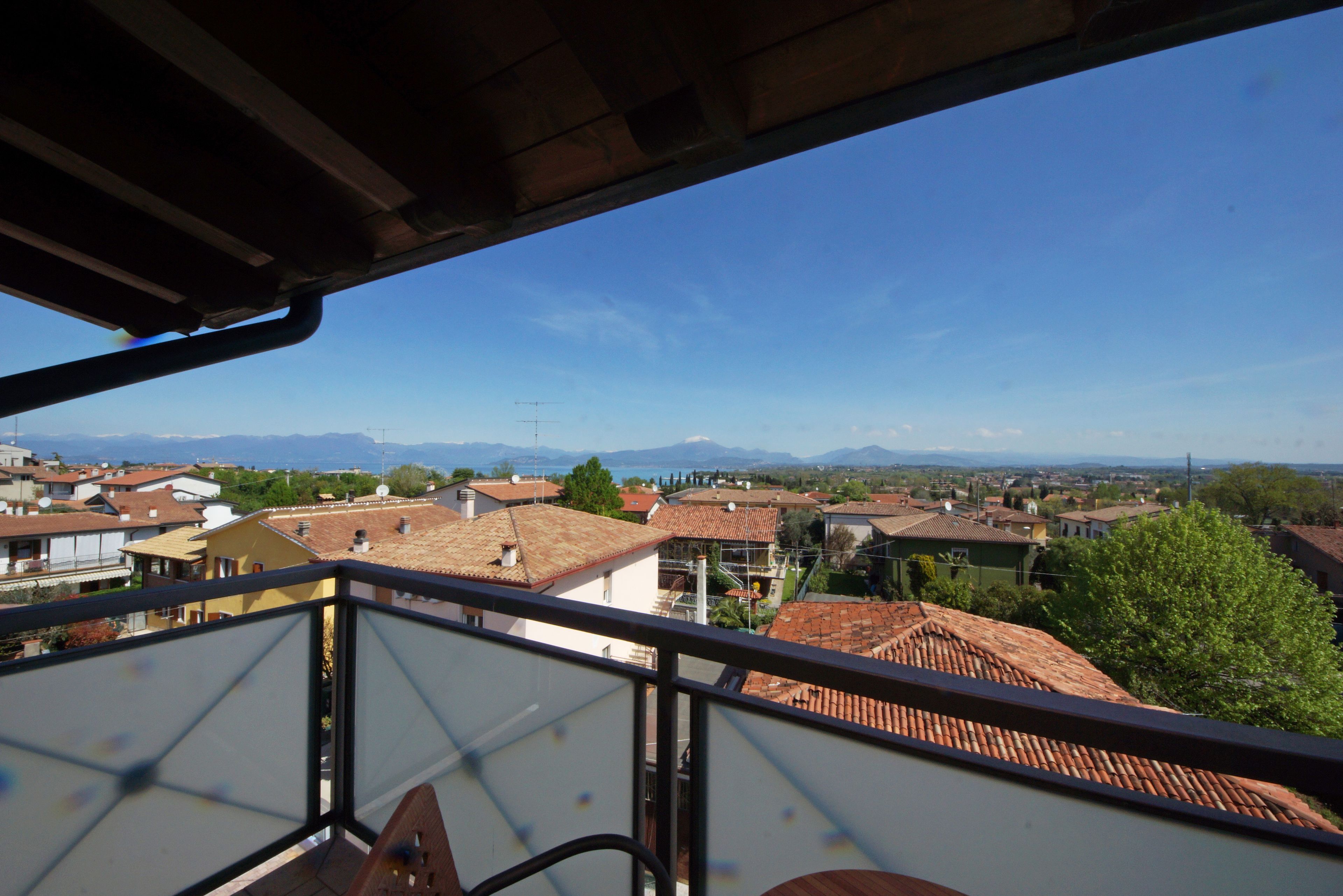 Un balcon offrant une vue sur la ville et les montagnes au loin.