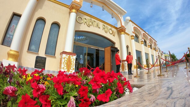 The exterior of the Oriental Riviera hotel with a grand entrance, a marble pathway, and a red flower garden. - Oriental Rivoli Hotel & SPA (Sharm El Sheikh)