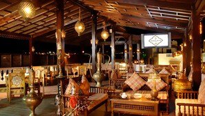 A traditional interior with ornate furniture, hanging lanterns, and a television screen displaying a menu. - Oriental Rivoli Hotel & SPA (Sharm El Sheikh)