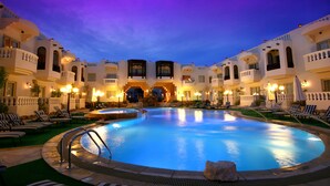 A hotel pool area with multiple lounge chairs and a central swimming pool. - Oriental Rivoli Hotel & SPA (Sharm El Sheikh)