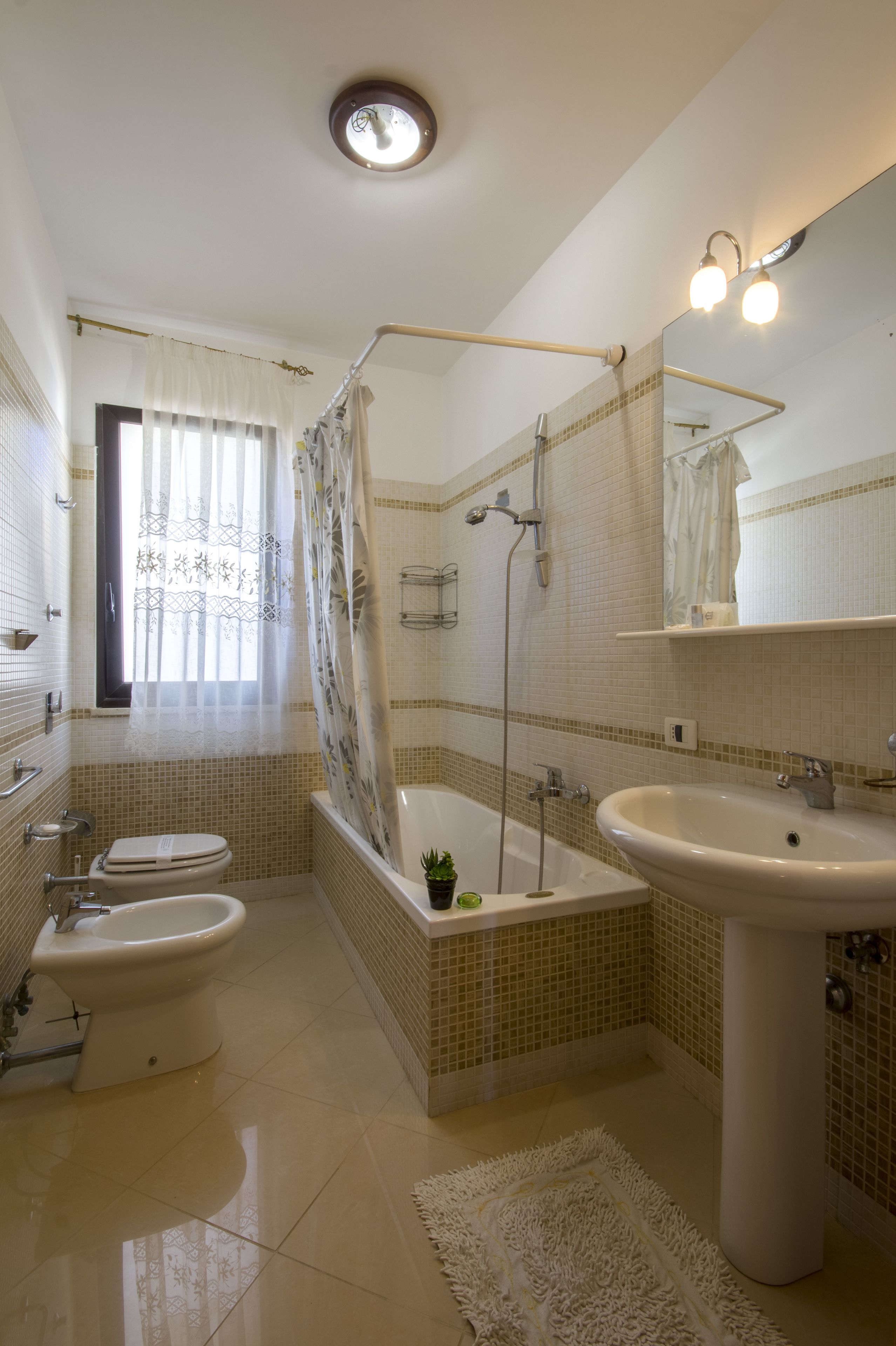 A bathroom with a bathtub, a sink, a toilet, and a bidet.