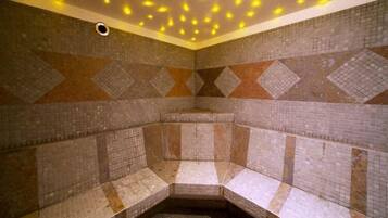 A tiled room with benches and a patterned wall design.