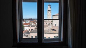Una ventana con vistas a un edificio histórico y una torre destacada.