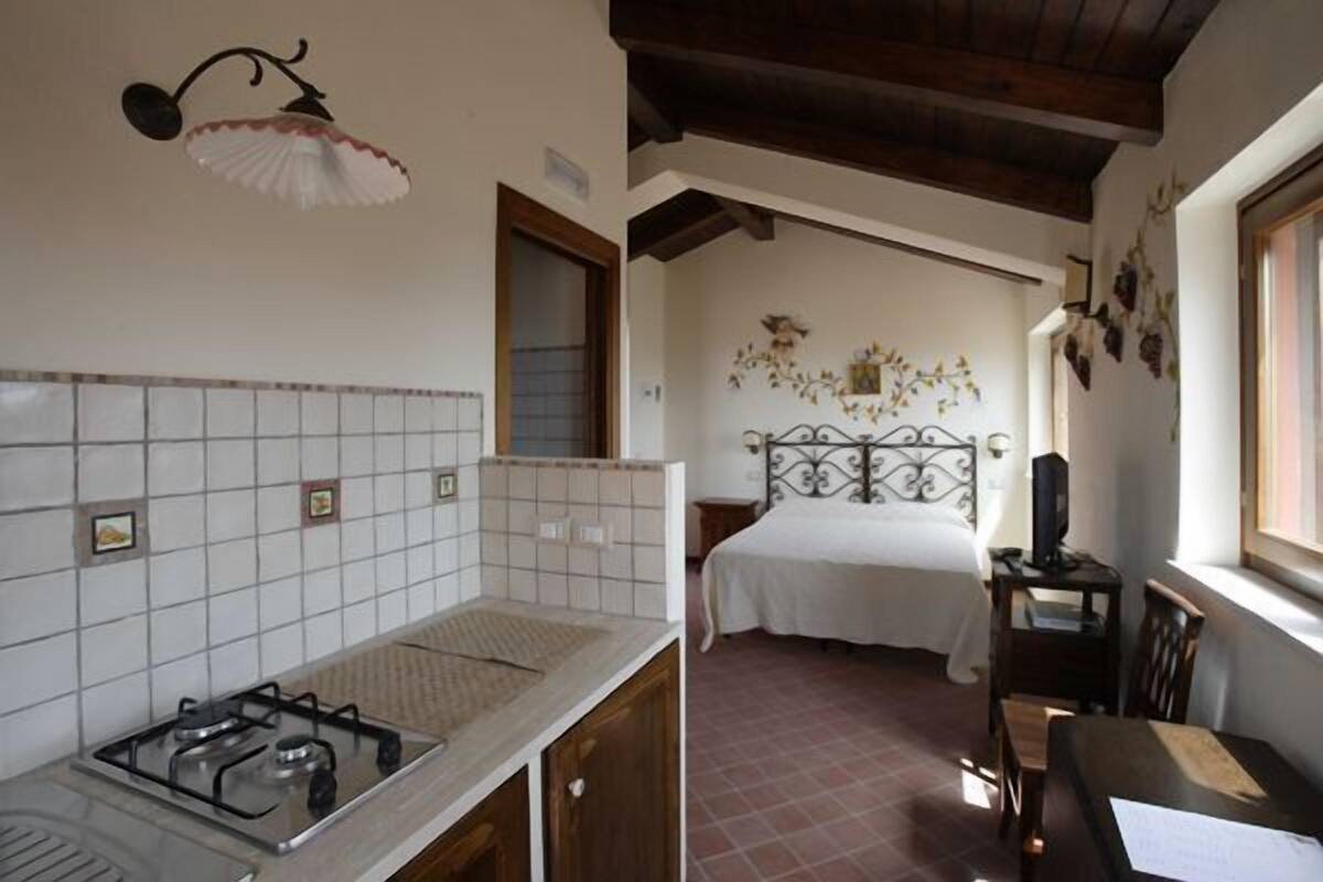 Una cocina con estufa a gas, un lavamanos y una ventana con vistas al jardín.
