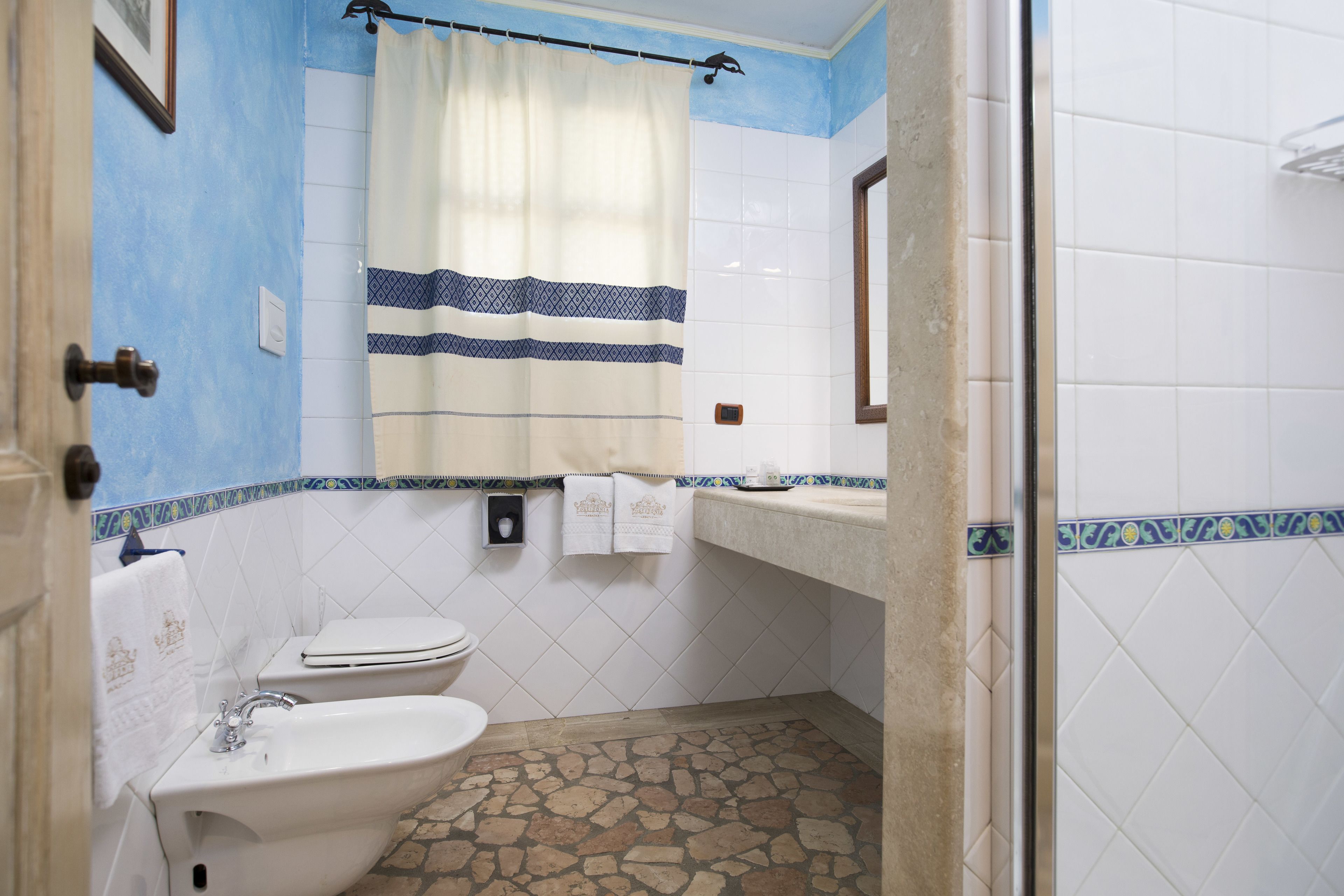 Une salle de bain équipée d’un lavabo, de toilettes et d’une douche.