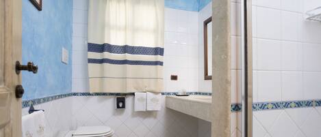 A bathroom with a sink, toilet, and shower area.