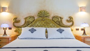 Una cama con un cabecero decorativo, dos lámparas de noche y almohadas a juego.