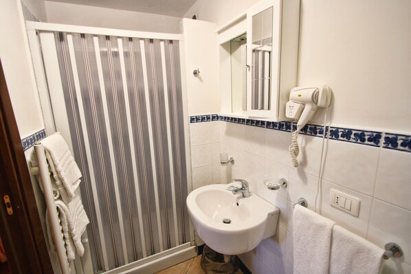 A bathroom with a shower, sink, and towel rack. - Casarufolo Paradise (Sorrento)