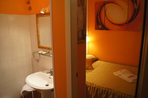 A bathroom with a white sink, a mirror, and a glass shelf. - La Mimosa Bed and Breakfast (Lucca)