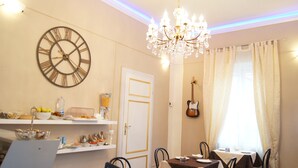 A dining area with a chandelier, a clock, and a guitar on the wall. - La Mimosa Bed and Breakfast (Lucca)