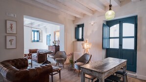 Amplia sala de estar con mesa de comedor de madera, sofá de cuero y diversas opciones de asientos.