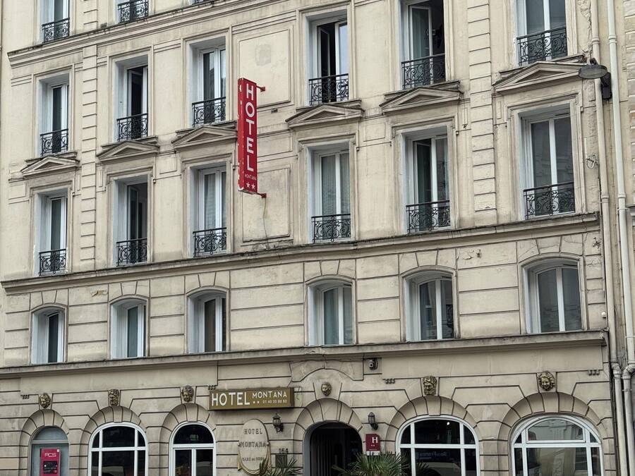 Hotel de vários andares com estilo arquitetônico clássico, com janelas em arco e molduras decorativas.