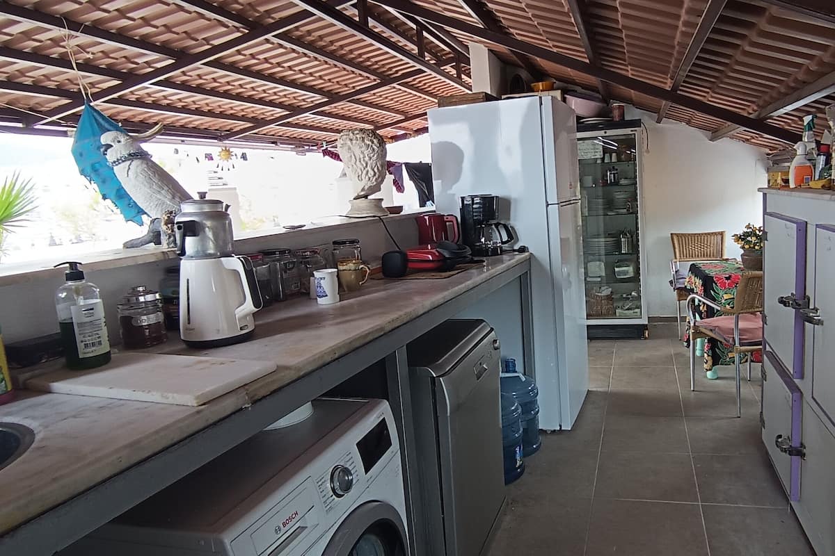 A compact kitchen with a washing machine, a refrigerator, and various kitchen appliances.