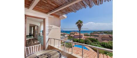 A balcony with a view of the sea and buildings.