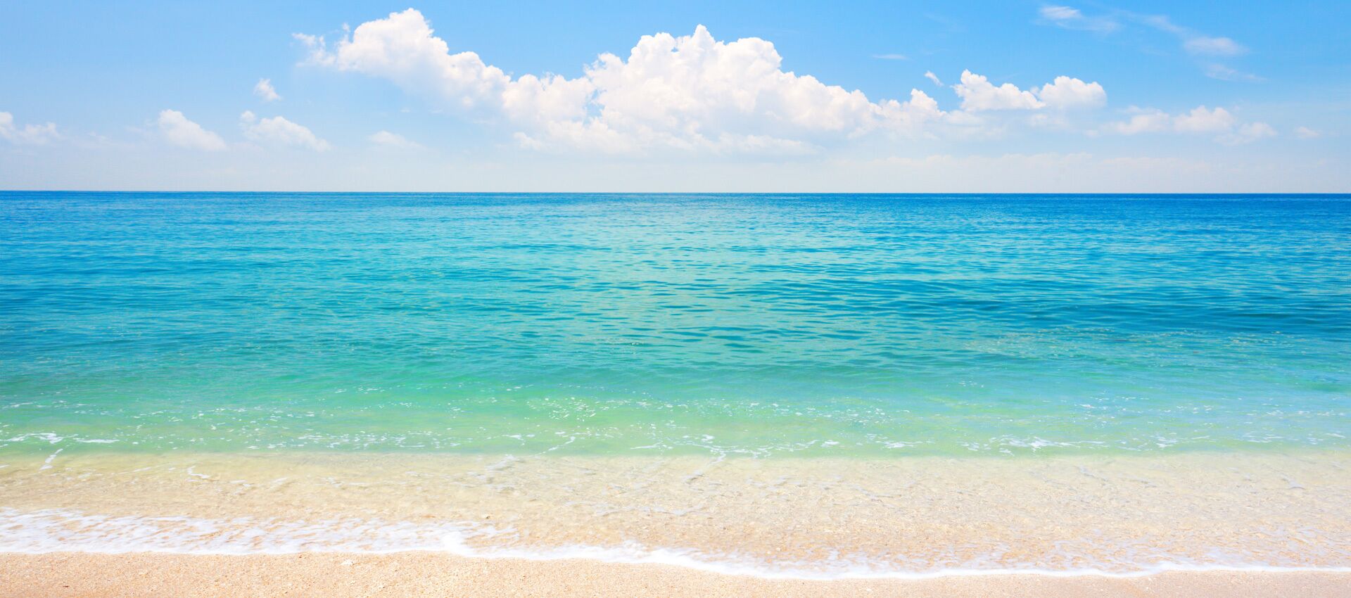 Una playa con agua turquesa cristalina y una orilla arenosa.