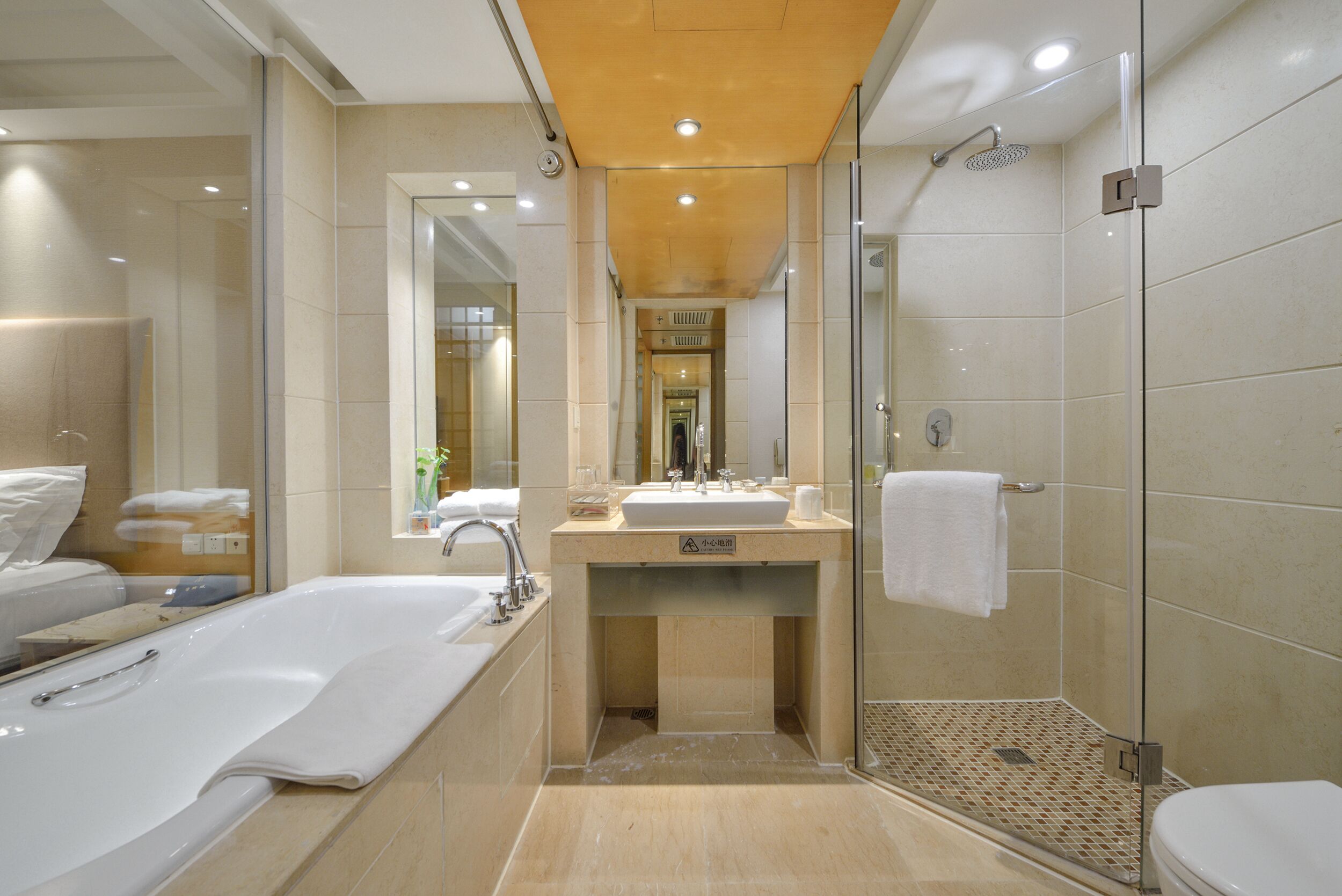A modern bathroom with a large bathtub, a separate shower area, and a vanity with a mirror.