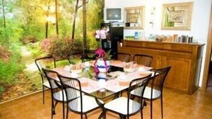A dining area with a round table, chairs, and a person standing by a counter. - Soggiorno Petrarca (Florence)