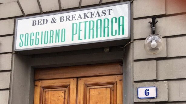 A wooden double door with a sign above stating "BED & BREAKFAST SOGGIORNO PETRARCA". - Soggiorno Petrarca (Florence)