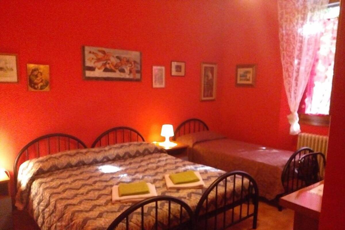 A room with two beds, a desk, and a radiator.