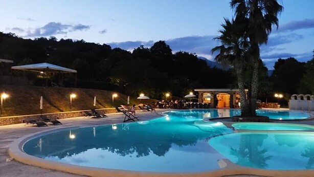A pool area with multiple pools, lounge chairs, and umbrellas.