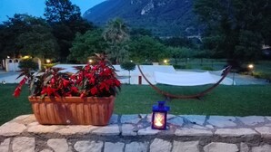 A stone wall with a hammock and a lantern.