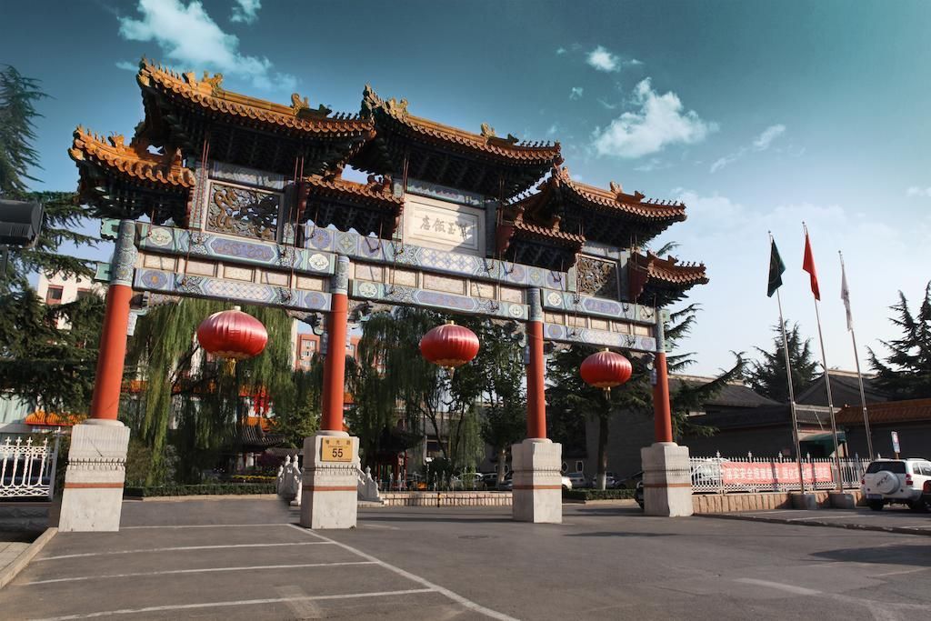A traditional Chinese gate with ornate architecture, including upturned eaves and intricate carvings.