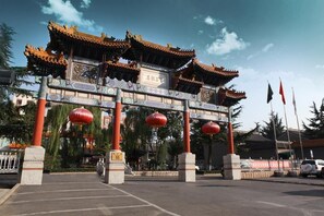Una puerta china tradicional con arquitectura ornamentada, que incluye aleros elevados y tallas detalladas.