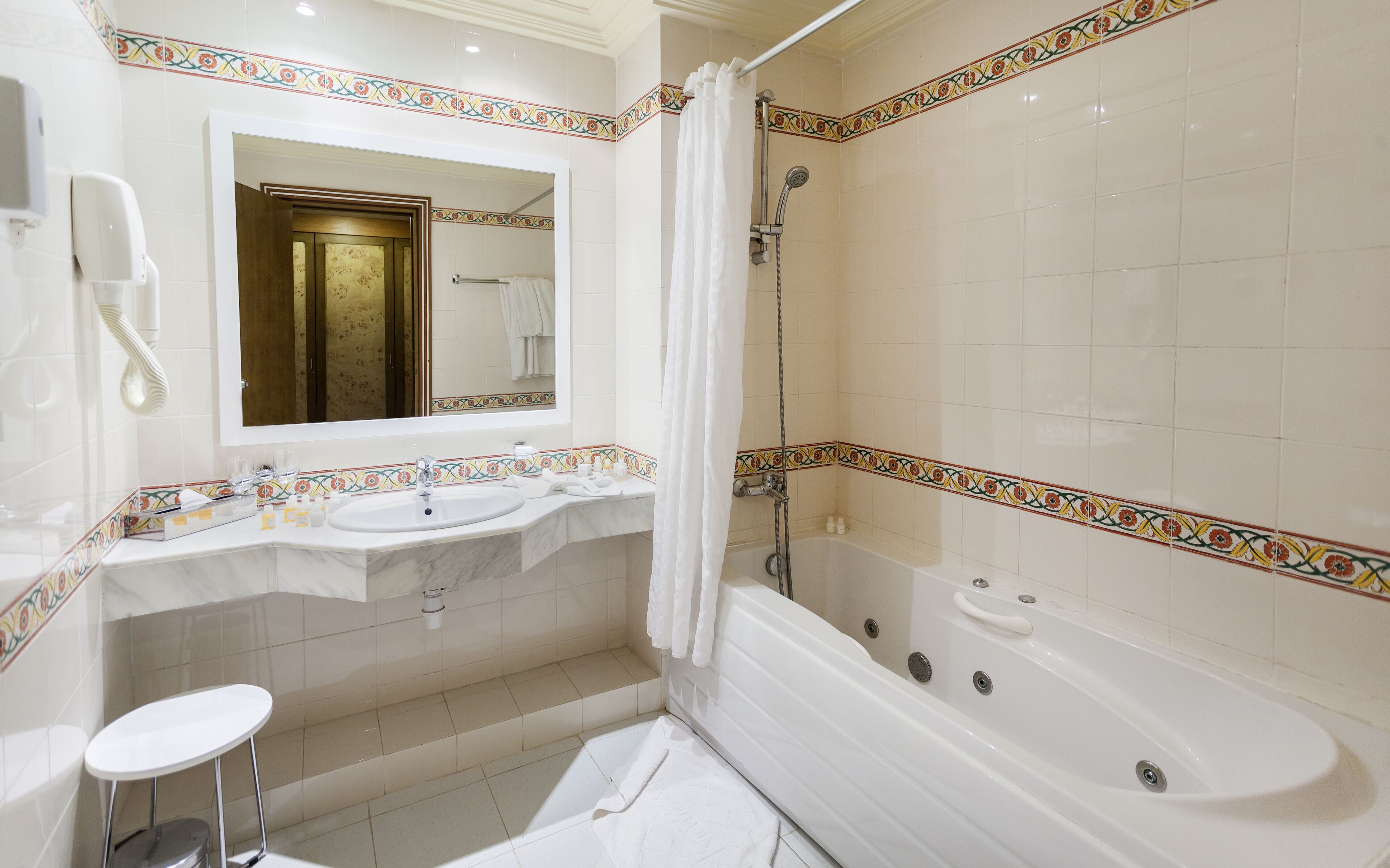 Un baño con bañera, dos lavamanos, un espejo, ducha y retrete.