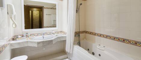 Un baño con bañera, dos lavamanos, un espejo, ducha y retrete.