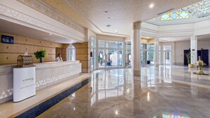 A hotel reception area with a marble floor, a reception desk, and a large window. - El Mouradi Tozeur (Tozeur)