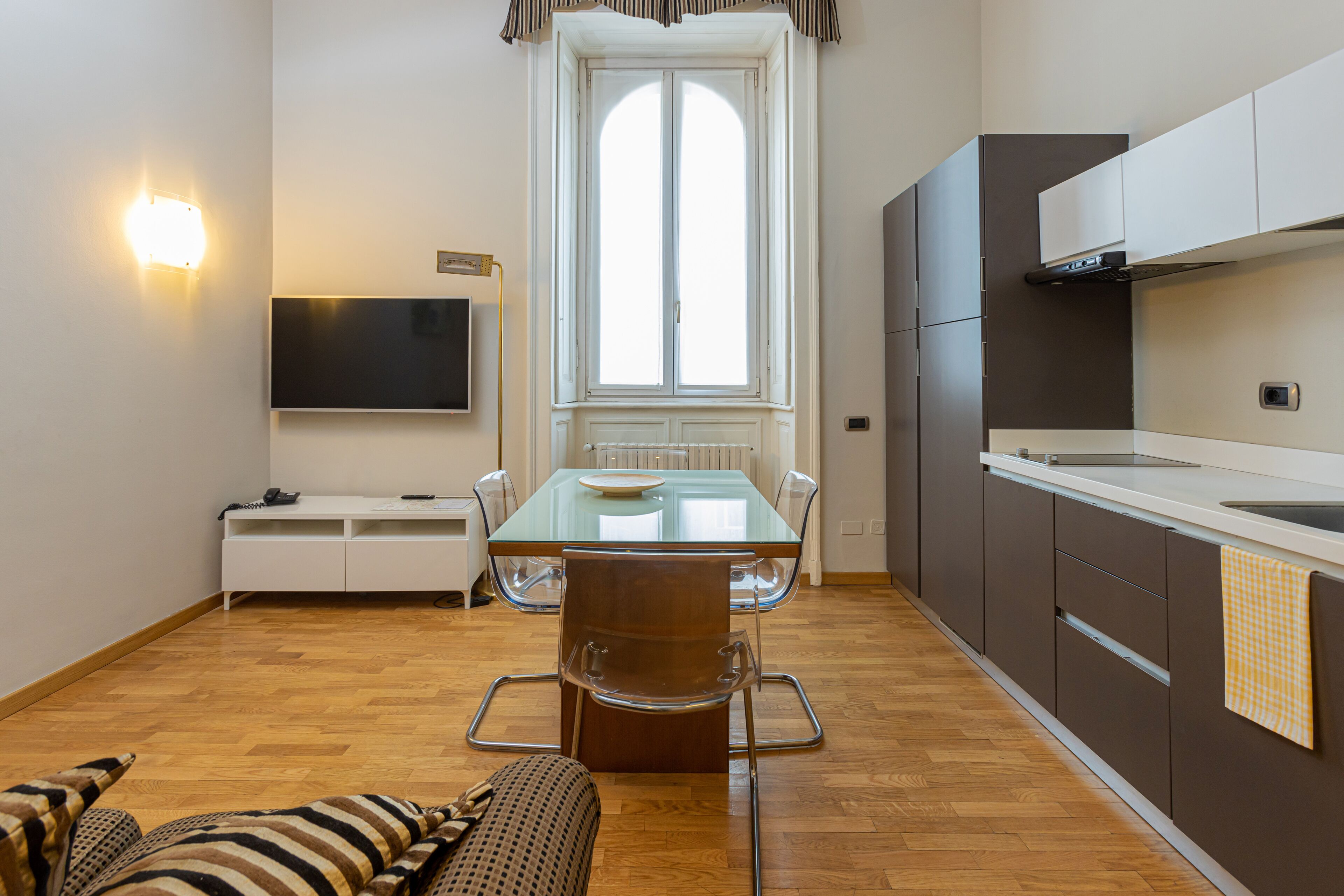 A modern kitchen with a dining table, chairs, and a built-in oven.