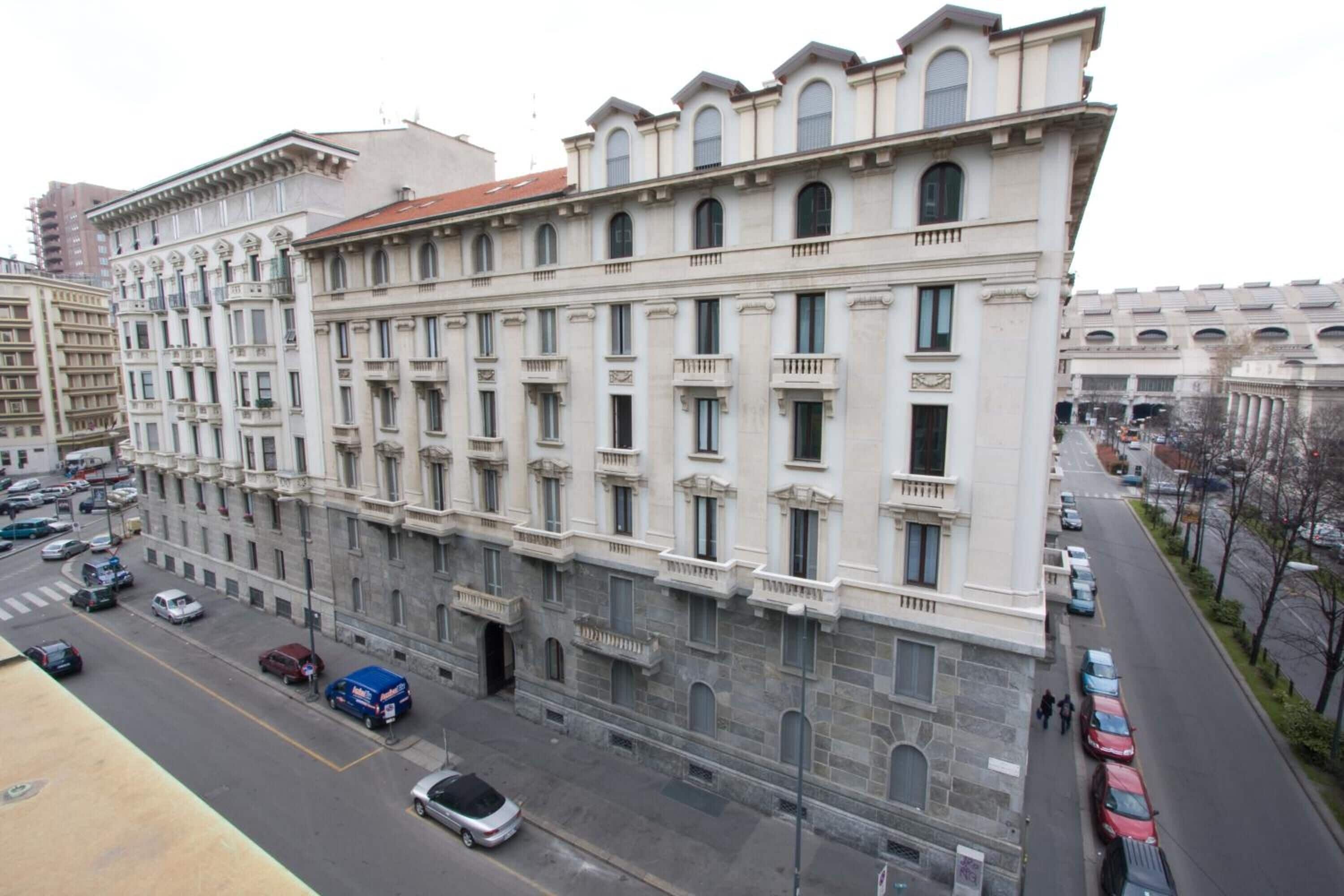 A multi-story building with a classical architectural style, featuring a symmetrical facade, large windows, and a central entrance.