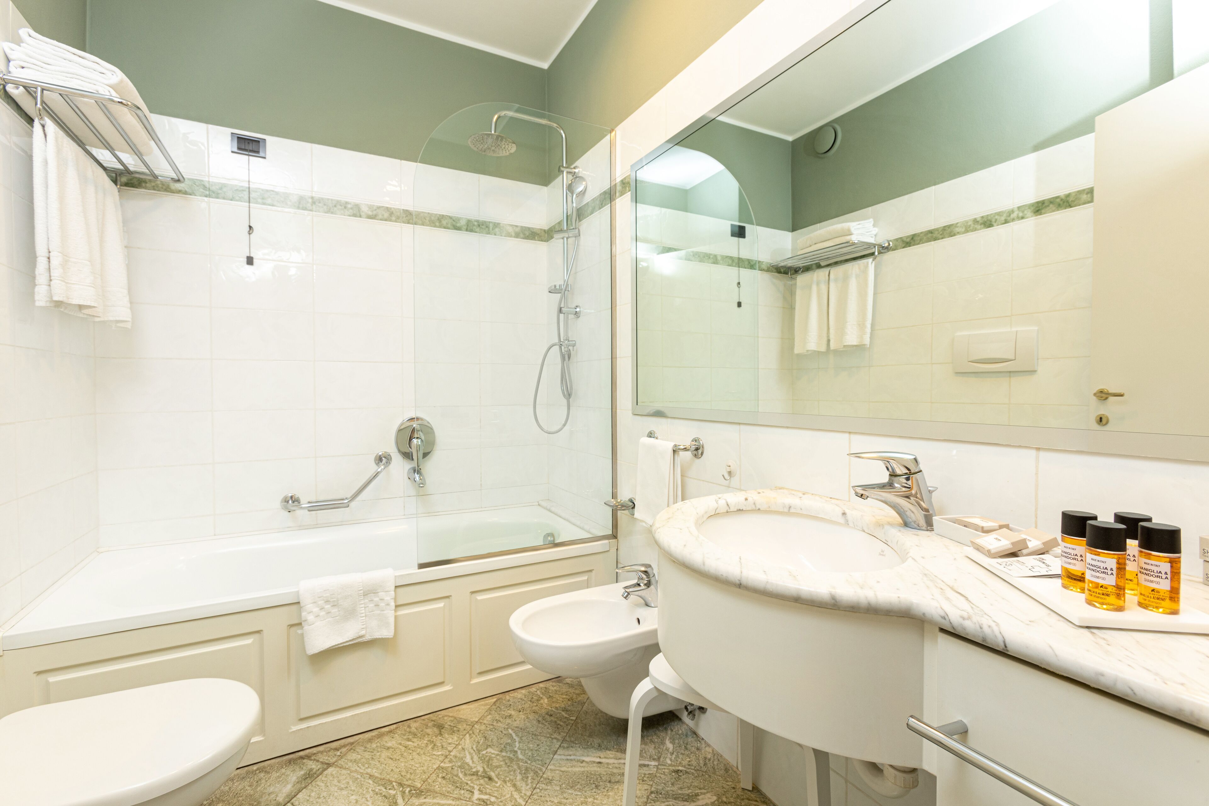 Ein modernes Badezimmer mit einer Glasdusche, einer freistehenden Badewanne, einem Standwaschbecken und einer Toilette.