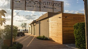 A modern building with a wooden facade and a sign that reads "Perrettting beach club - Restaurante". - Majestic (Cervia)