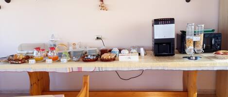 A breakfast buffet setup with various food items and a coffee machine.