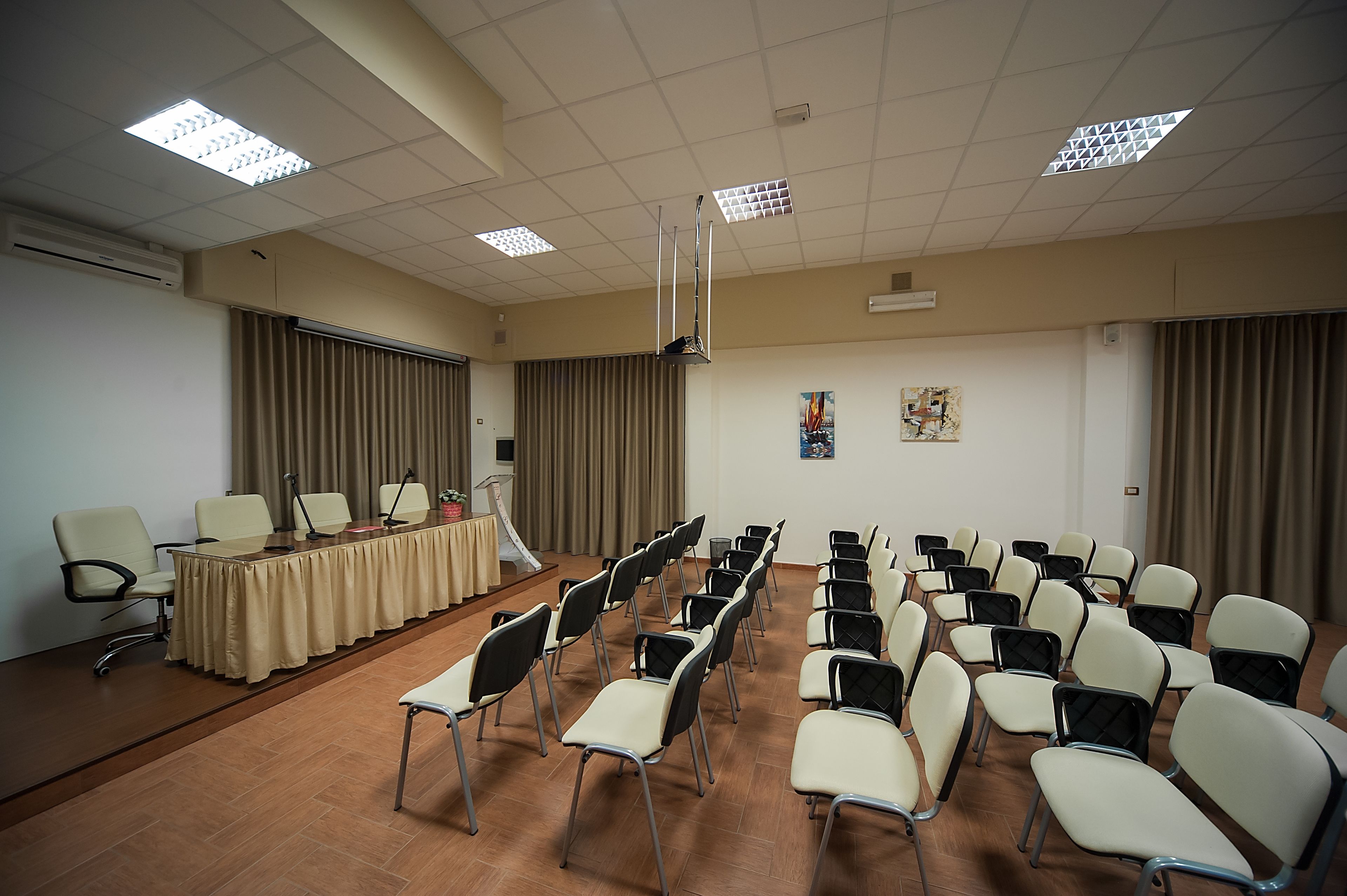 A conference room with a long table, chairs, and a podium.