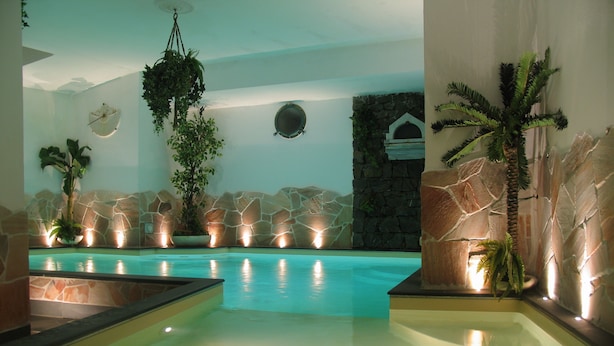 An indoor swimming pool with stone walls and plants. - Hotel Due Mari (Sestri Levante)