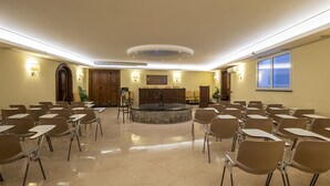 A conference room with a central fountain, multiple tables, and chairs arranged for meetings. - Hotel Due Mari (Sestri Levante)