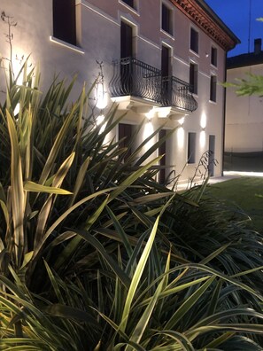 A building with a balcony and a well-lit facade. - Villa Giotto Luxury Suite & Apartments (Mestre)