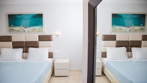 A hotel room with two beds, a nightstand, a bedside table, and a large mirror. - Brentanos Apartments ~ A ~ View of Paradise (Corfu)