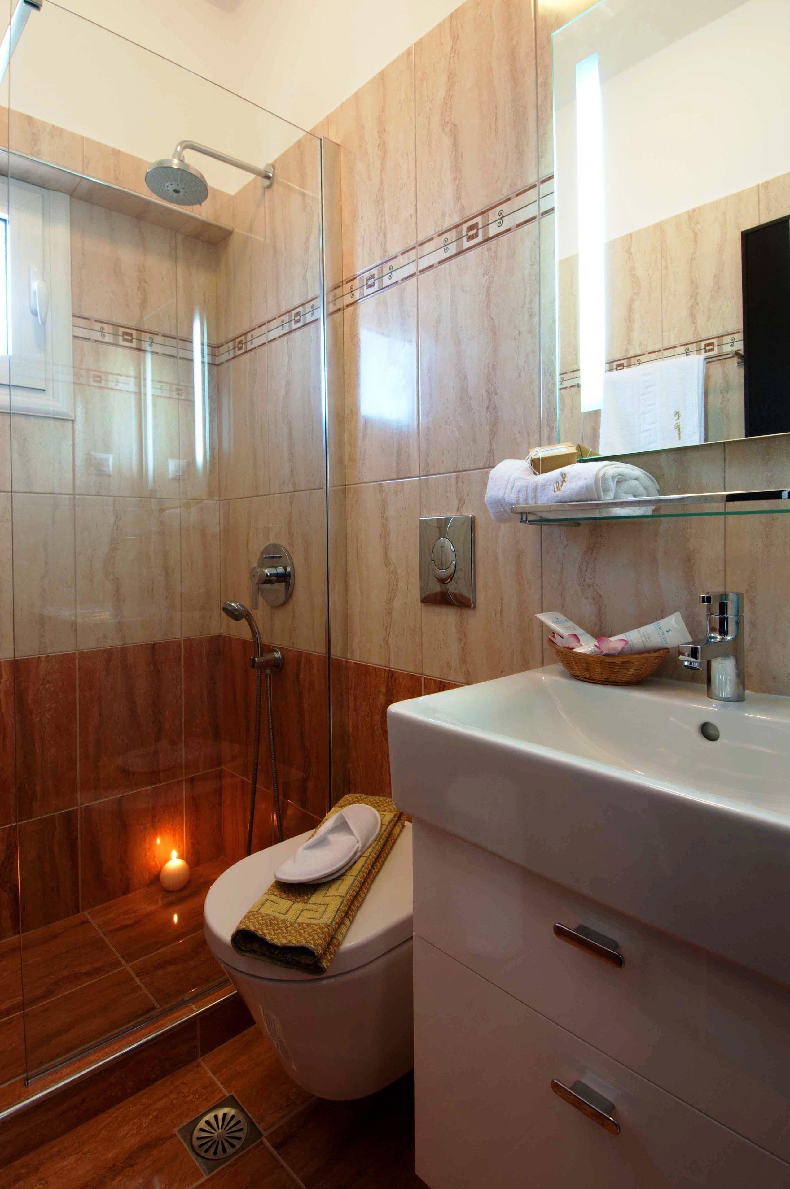 A modern bathroom with a glass-enclosed shower, a white sink, and a vanity with drawers.