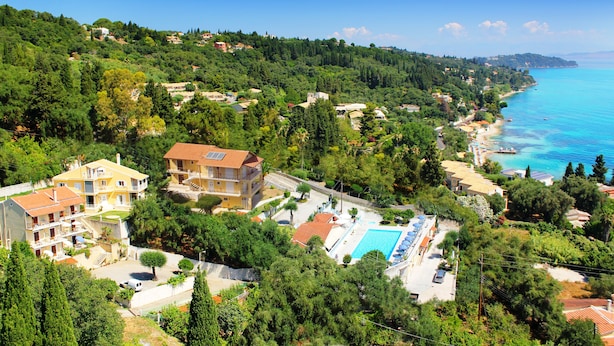 A coastal residential area with houses, a swimming pool, and a clear view of the sea. - Brentanos Apartments ~ A ~ View of Paradise (Corfu)