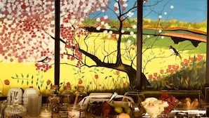A table with jars of honey, a bowl of fruit, and a painting of a tree with birds. - Brentanos Apartments ~ A ~ View of Paradise (Corfu)