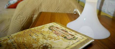 A map of Caltagirone on a wooden table next to a white lamp.