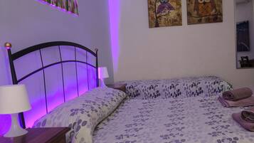 Una camera da letto con un letto, un comodino, una cassettiera e decorazioni a parete.
